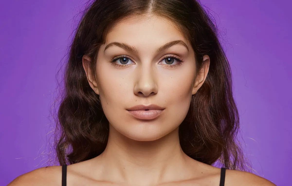 A detailed portrait against a purple backdrop